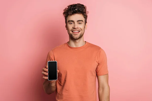Веселый Молодой Человек Улыбается Камеру Показывая Смартфон Пустым Экраном Розовом — стоковое фото