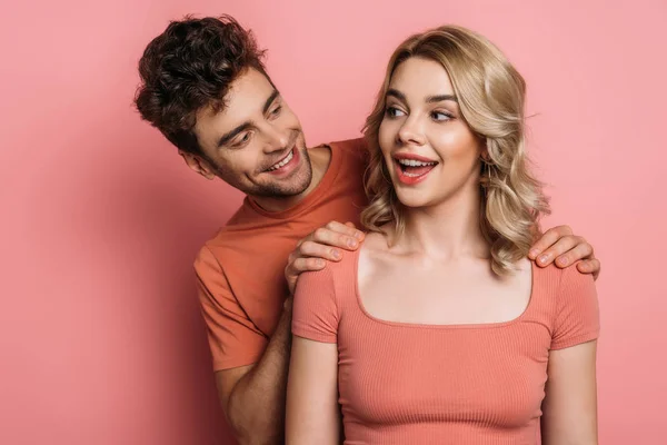 Fröhlicher Mann Berührt Schultern Von Flirty Mädchen Auf Rosa Hintergrund — Stockfoto