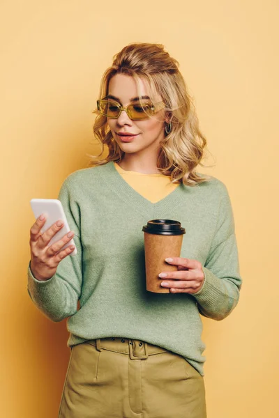 Stylish Smiling Girl Holding Coffee While Chatting Smartphone Yellow Background — Stock Photo, Image