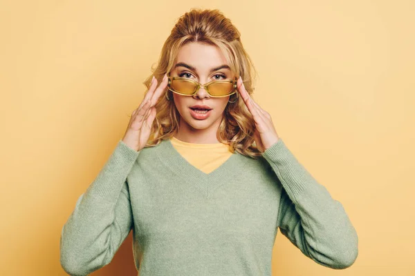 Attractive Confident Girl Touching Glasses While Looking Camera Yellow Background — Stock Photo, Image