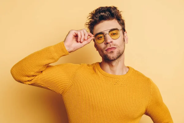 Handsome Confident Man Touching Glasses While Looking Camera Yellow Background — Stock Photo, Image