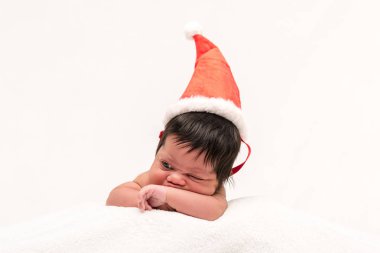 Noel Baba şapkalı melez yeni doğmuş bebek beyazlar içinde izole edilmiş. 