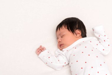 overhead view of cute bi-racial newborn in baby romper sleeping isolated on white  clipart