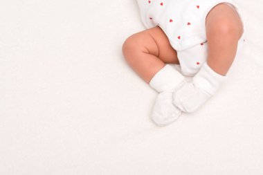 Bebek arabasının içinde yeni doğmuş şirin bir bebek ve beyaz çorapların kesilip atılmış görüntüsü. 