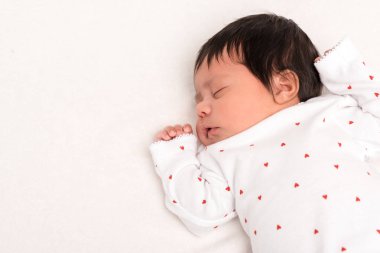 top view of adorable bi-racial newborn in baby romper sleeping isolated on white  clipart