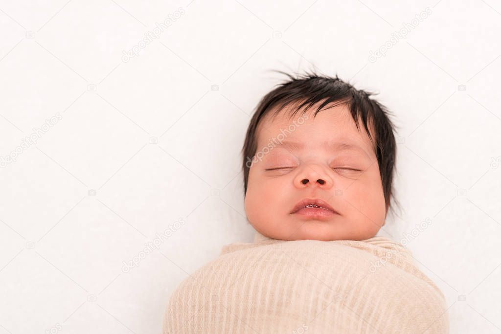top view of mixed race baby wrapped in blanket sleeping isolated on white 