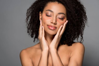 Çıplak Afro-Amerikan kızı. Gözleri kapalı. Hidrojel göz bantları var.