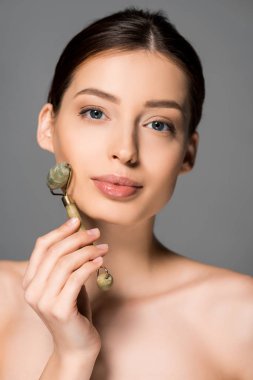 Gri renkte, yeşil masaj aleti kullanan çekici bir kız.