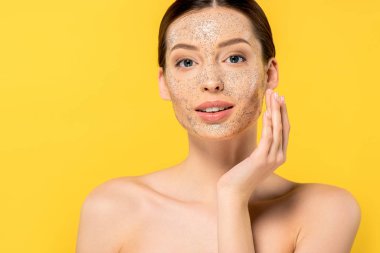 Maske takan çıplak genç bir kadının portresi, sarıya izole edilmiş.