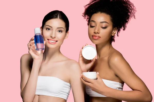 Mujeres Multirraciales Felices Sosteniendo Crema Cosmética Removedor Maquillaje Aislado Rosa — Foto de Stock