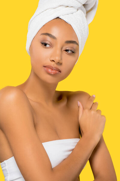 beautiful african american girl with towel on head, isolated on yellow