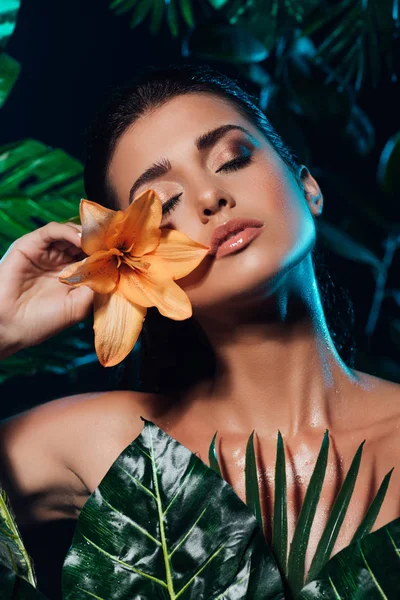 新鮮な葉の近くに蘭を持つ若い魅力的な女性 — ストック写真