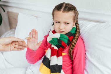sad ill daughter in scarf does not want to take medicines clipart