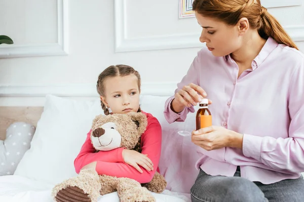 Madre Che Sciroppo Alla Figlia Malata Triste Con Orsacchiotto — Foto Stock