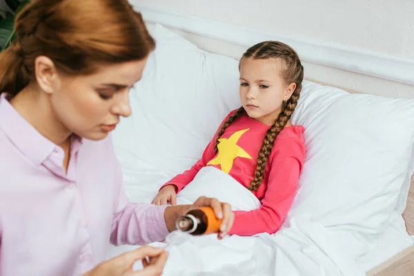 Worried Mother Giving Syrup Sick Daughter Bed — Stock Photo, Image