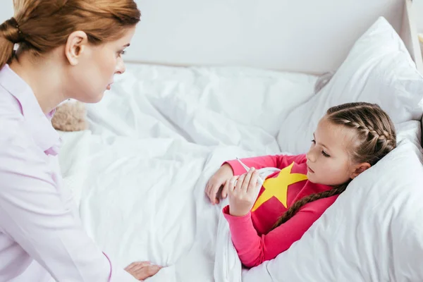 Beteg Lánya Lázas Nézi Hőmérő Miközben Feküdt Ágyban Anya Közelében — Stock Fotó