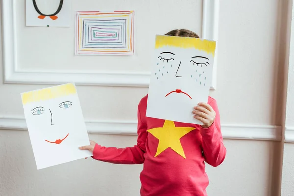 Barn Hålla Två Målningar Med Glada Och Ledsna Ansikten — Stockfoto