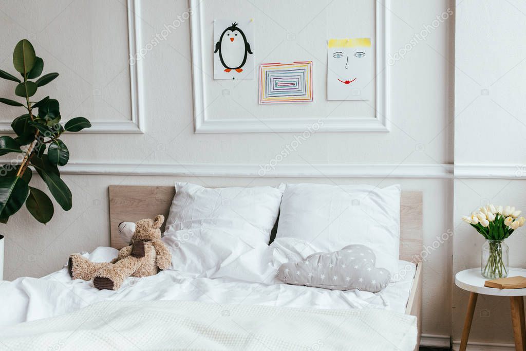interior of empty children room with bed, teddy bear and paintings