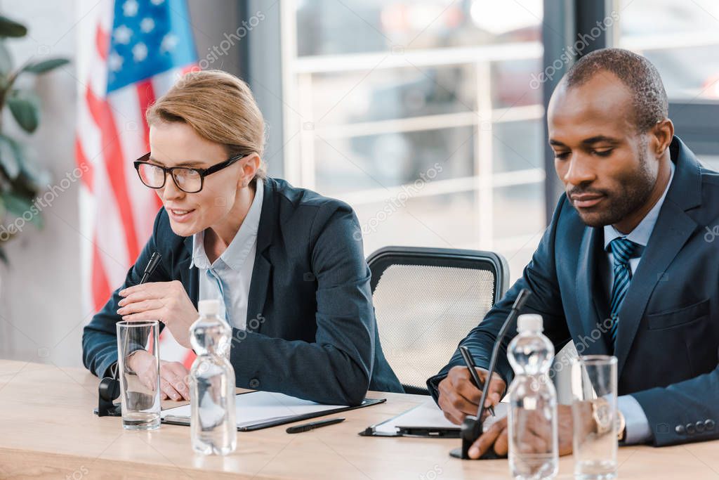 attractive diplomat talking in microphone near african american representative 