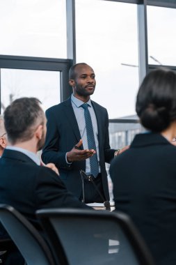 Resmi olarak seçilmiş Afrikalı Amerikalı diplomatın seçici odak noktası iş adamları ve iş kadınlarının yanında el kol hareketi yapmak. 