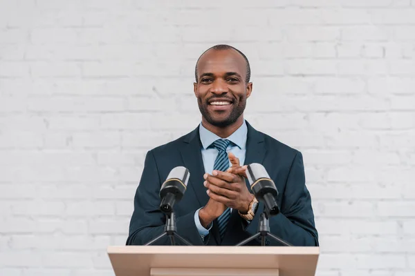 Χαρούμενος Αφρικάνικος Αμερικανός Ομιλητής Χειροκροτεί Κοντά Στα Μικρόφωνα — Φωτογραφία Αρχείου