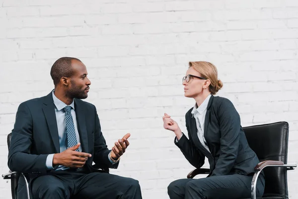 Sida Syn Afrikansk Amerikansk Affärsman Gestikulerar Nära Affärskvinna Glasögon Sitter — Stockfoto