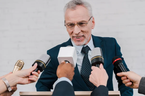 Cropped View Journalists Holding Microphones Happy Bearded Diplomat Glasses — Stock Photo, Image