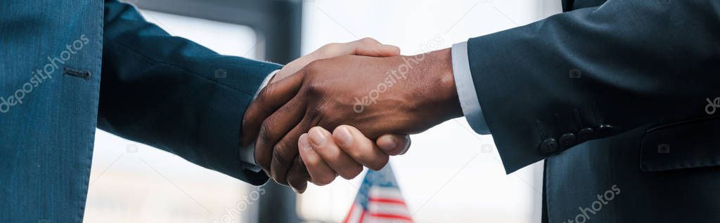 panoramic shot of multicultural diplomats shaking hands 