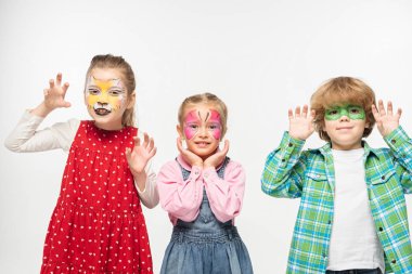 cheerful friends with colorful face paintings showing frightening gestures while looking at camera isolated on white clipart