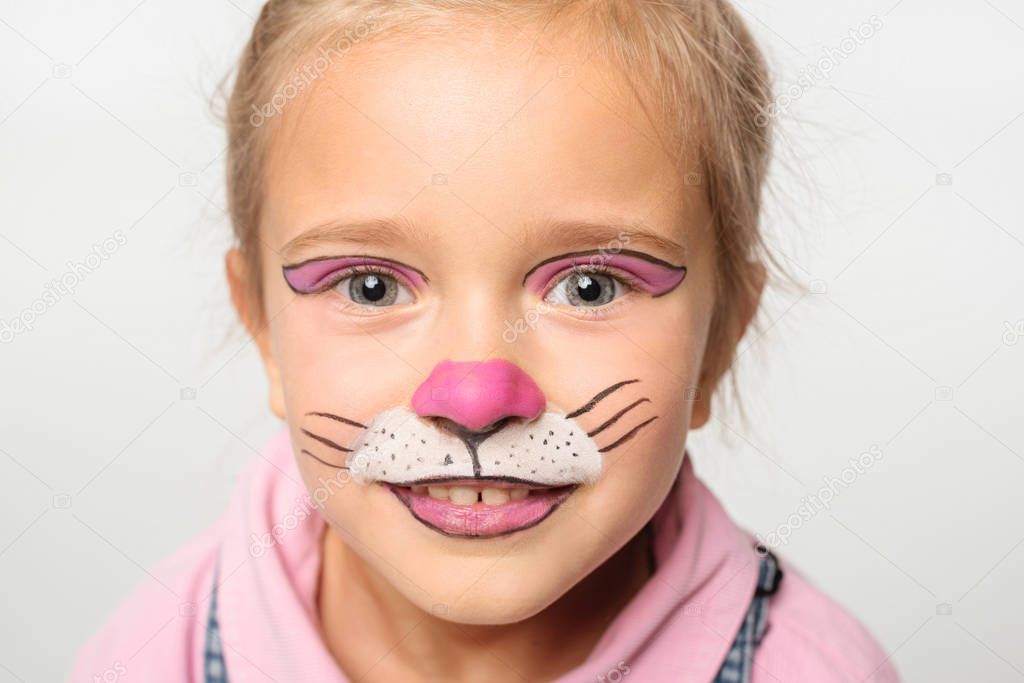 portrait of smiling child with cat muzzle painting on face looking at camera isolated on white