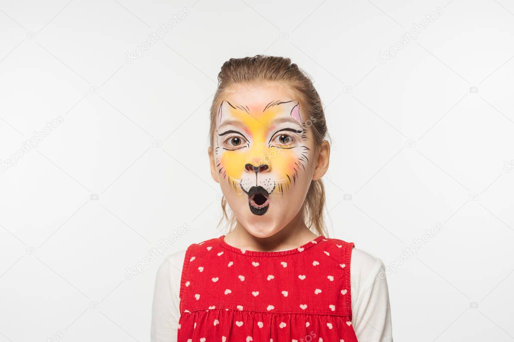 portrait of adorable child with tiger muzzle painting on face looking at camera isolated on white