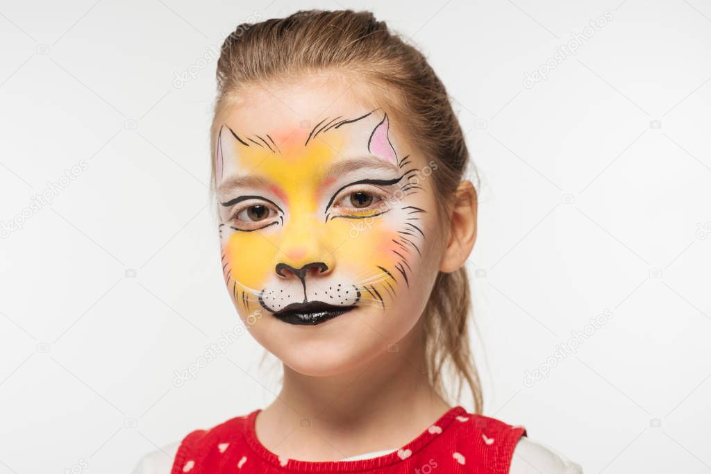 portrait of adorable child with tiger muzzle painting on face looking at camera isolated on white