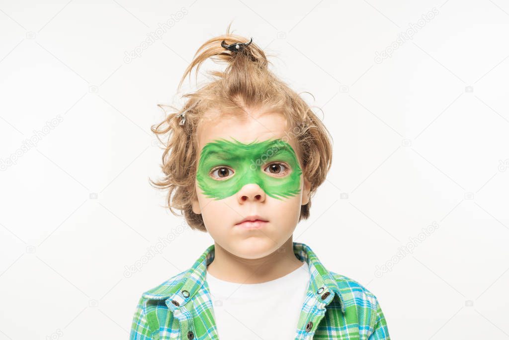 shaggy boy with gecko mask painted on face looking at camera isolated on white