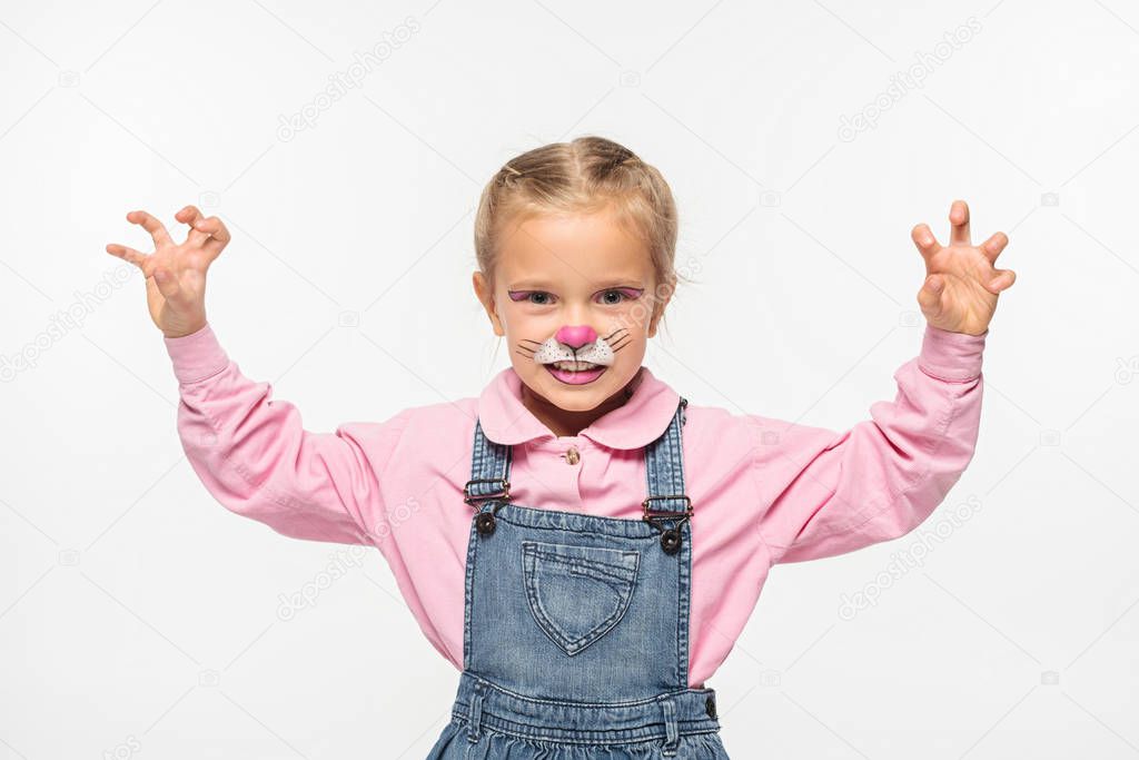 cute child with cat muzzle painting on face showing frightening gesture while looking at camera isolated on white