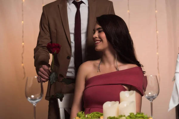 赤いバラをプレゼントするエレガントな男のクロップドビューはバレンタインに幸せなガールフレンドに — ストック写真