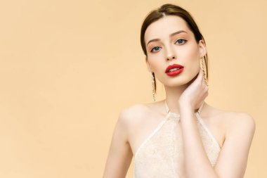 young attractive woman looking at camera isolated on beige 