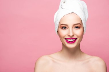 happy naked woman in white towel looking at camera isolated on pink 