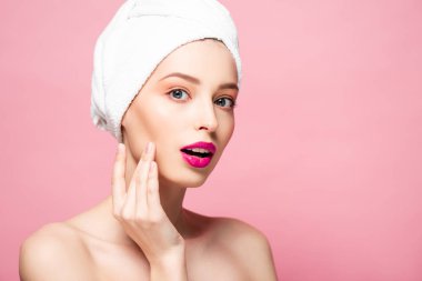 surprised naked woman in white towel isolated on pink 