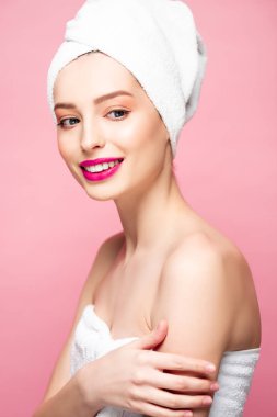 smiling young woman in towel on head isolated on pink 
