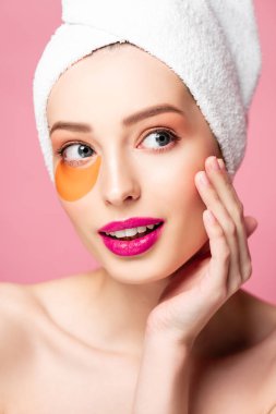 happy naked girl with eye patch looking away isolated on pink 