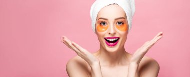 panoramic shot of excited girl with eye patches on face looking at camera isolated on pink 