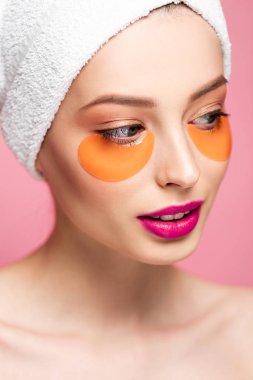 attractive naked girl with eye patches on face looking away isolated on pink 