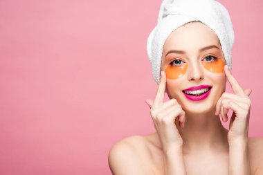 happy naked girl touching face with eye patches isolated on pink 