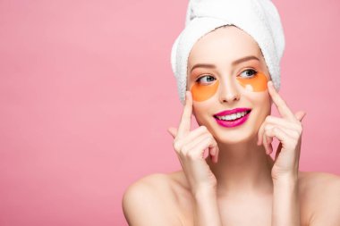 cheerful naked girl touching face with eye patches isolated on pink 