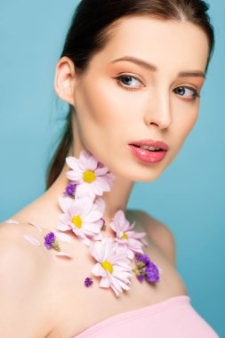 young woman with flowers on neck isolated on blue 