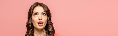 panoramic shot of surprised young woman looking up isolated on pink clipart