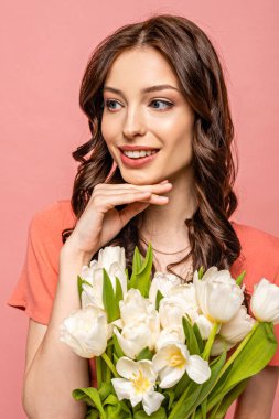 Hayalperest, mutlu kız gülümseyen ve başka tarafa bakan Pembe üzerinde izole beyaz laleler buketi tutan