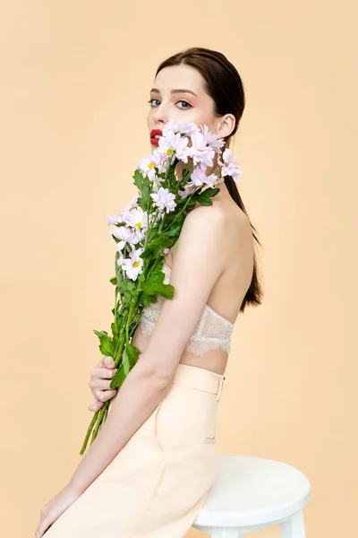 Mooie Vrouw Met Bloeiende Bloemen Zitten Stoel Geïsoleerd Beige — Stockfoto