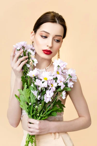 Όμορφη Νεαρή Γυναίκα Κοιτάζει Μακριά Κοντά Ανθισμένα Λουλούδια Χρυσάνθεμα Απομονωμένα — Φωτογραφία Αρχείου