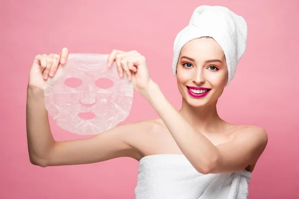 Happy Girl Looking Camera Holding Moisturizing Face Mask Isolated Pink — Stok fotoğraf